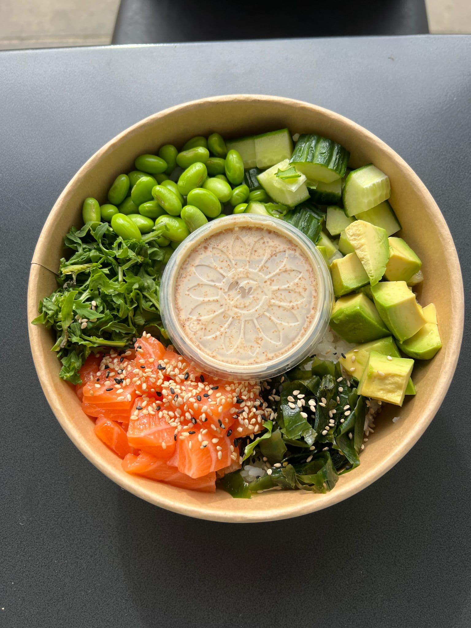 Poke Bowl von oben mit Lachs, Edamame, Avocado, Gurke und Seetang